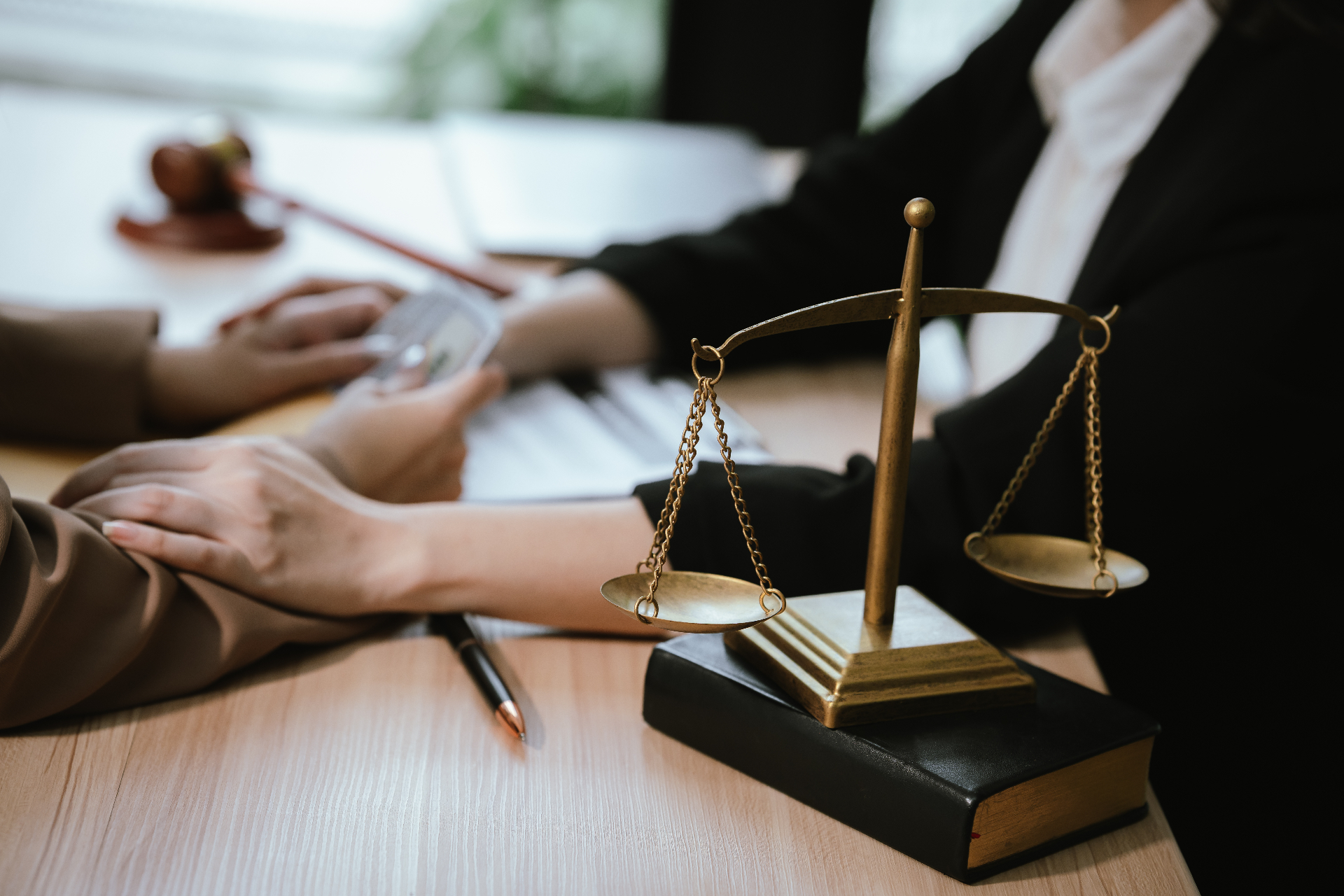 Atendimento jurídico com balança da justiça sobre a mesa